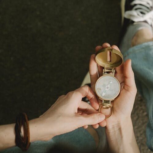 Person holding a compass to illustrate finding a coach